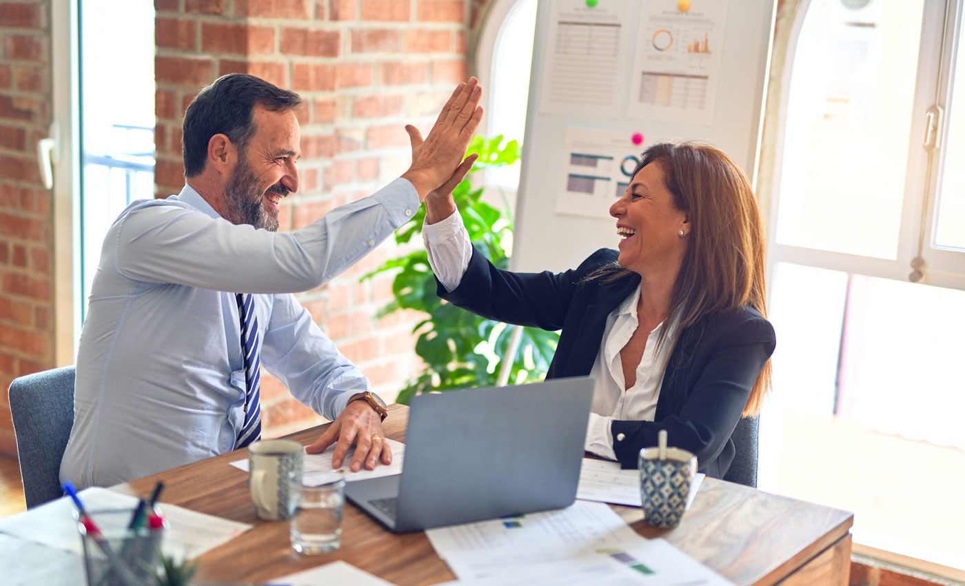how to onboard new employees - man and woman high fiving each other